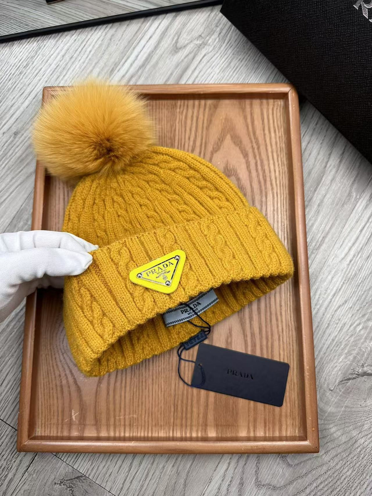Cable-knit beanie with embroidered logo, featuring a mohair-like texture—a warm winter hat.