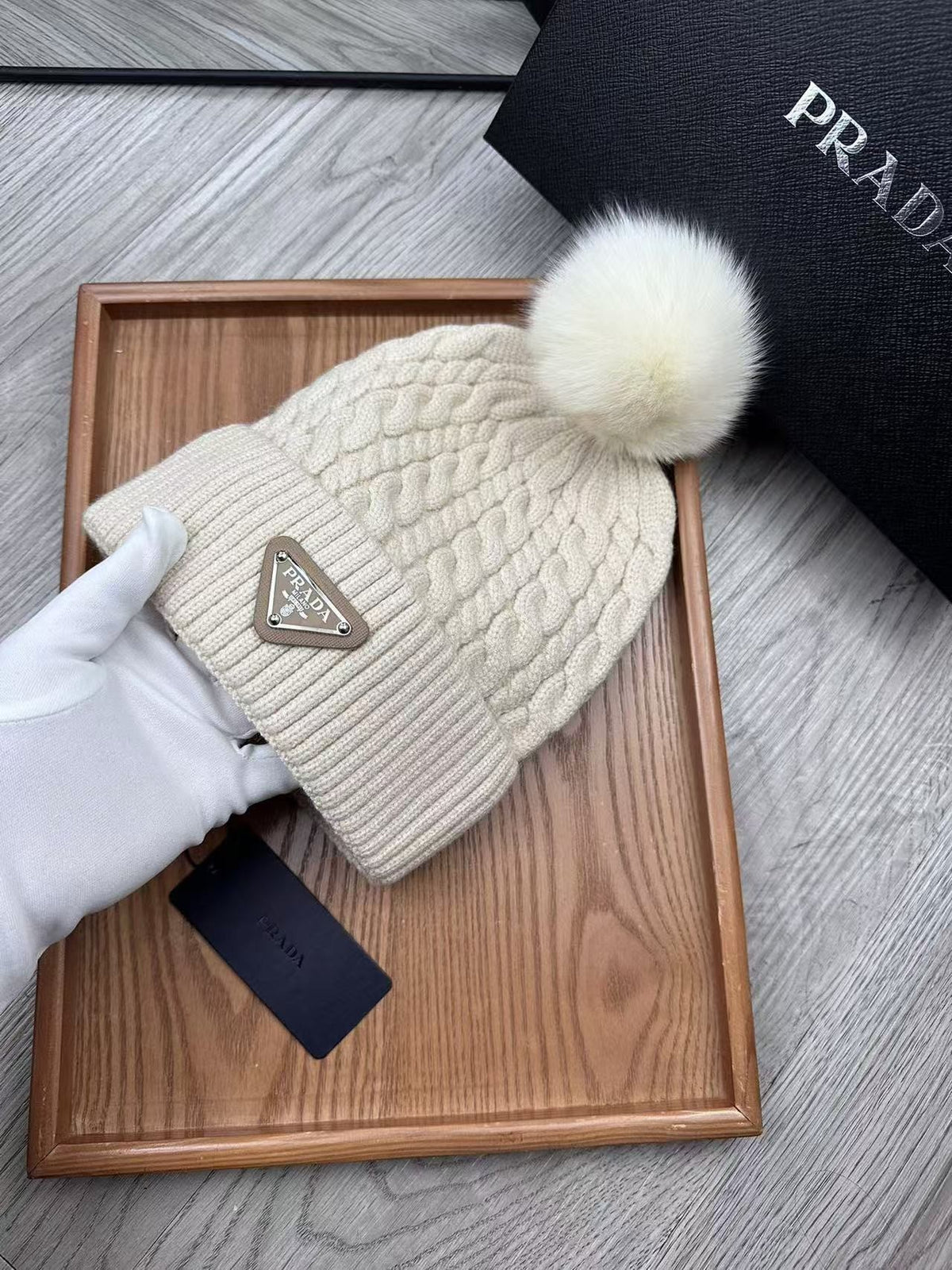 Cable-knit beanie with embroidered logo, featuring a mohair-like texture—a warm winter hat.