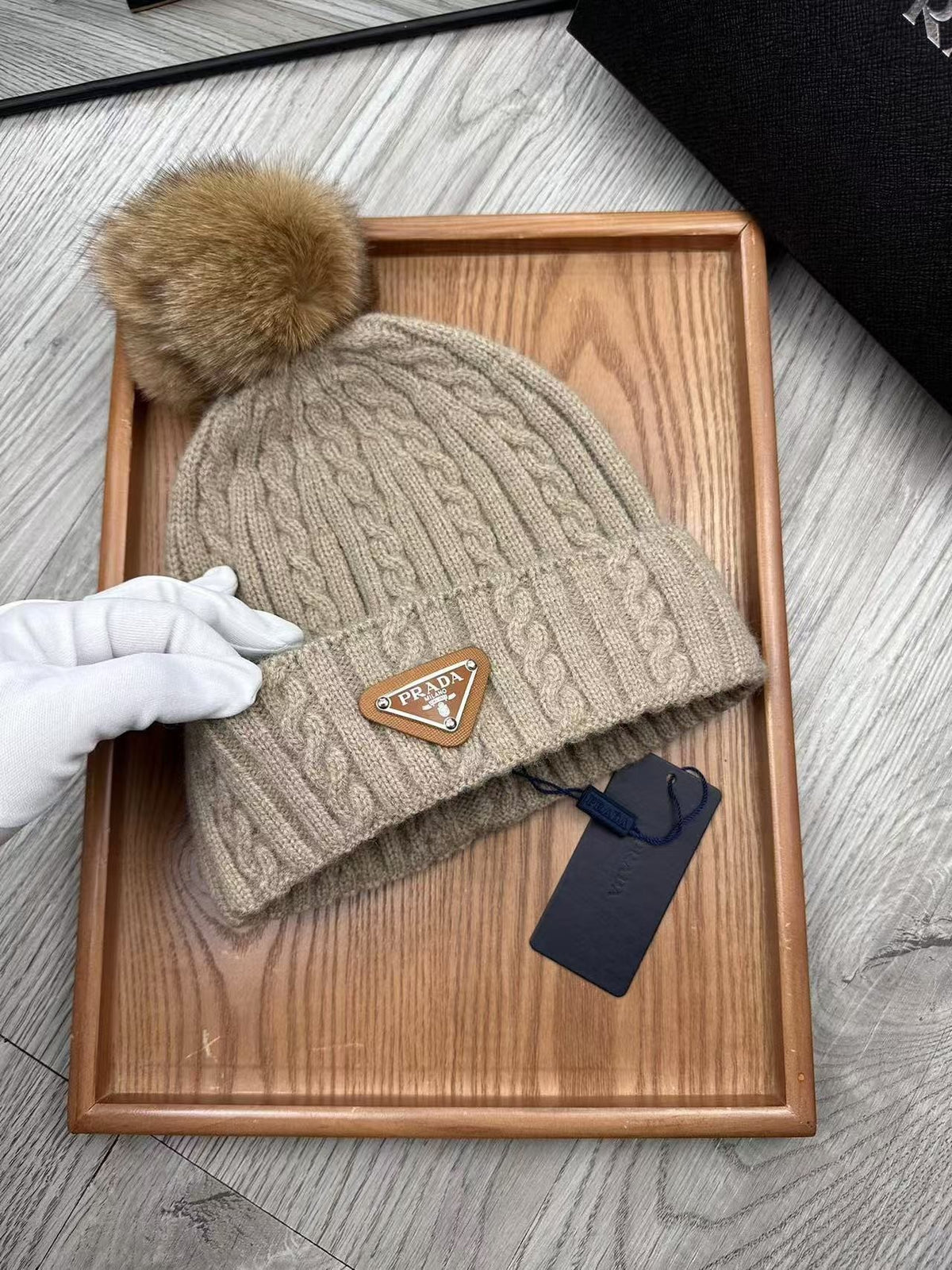 Cable-knit beanie with embroidered logo, featuring a mohair-like texture—a warm winter hat.