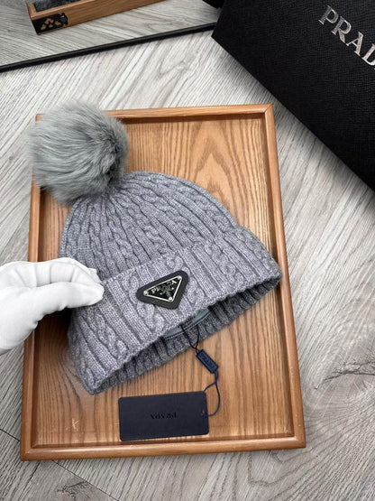 Cable-knit beanie with embroidered logo, featuring a mohair-like texture—a warm winter hat.