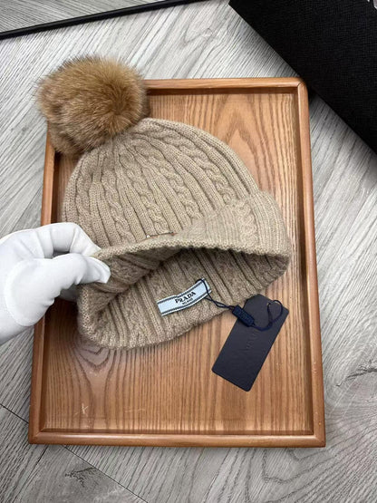 Cable-knit beanie with embroidered logo, featuring a mohair-like texture—a warm winter hat.