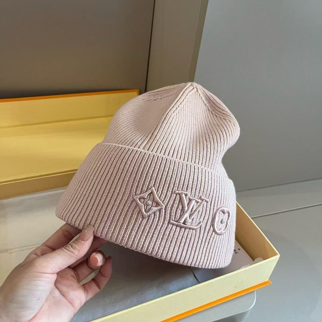 Rib-knit beanie featuring four different embroidered designs; a warm, cuffed winter hat.