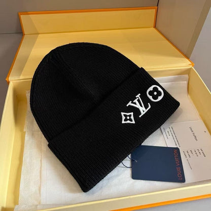 Rib-knit beanie featuring four different embroidered designs; a warm, cuffed winter hat.